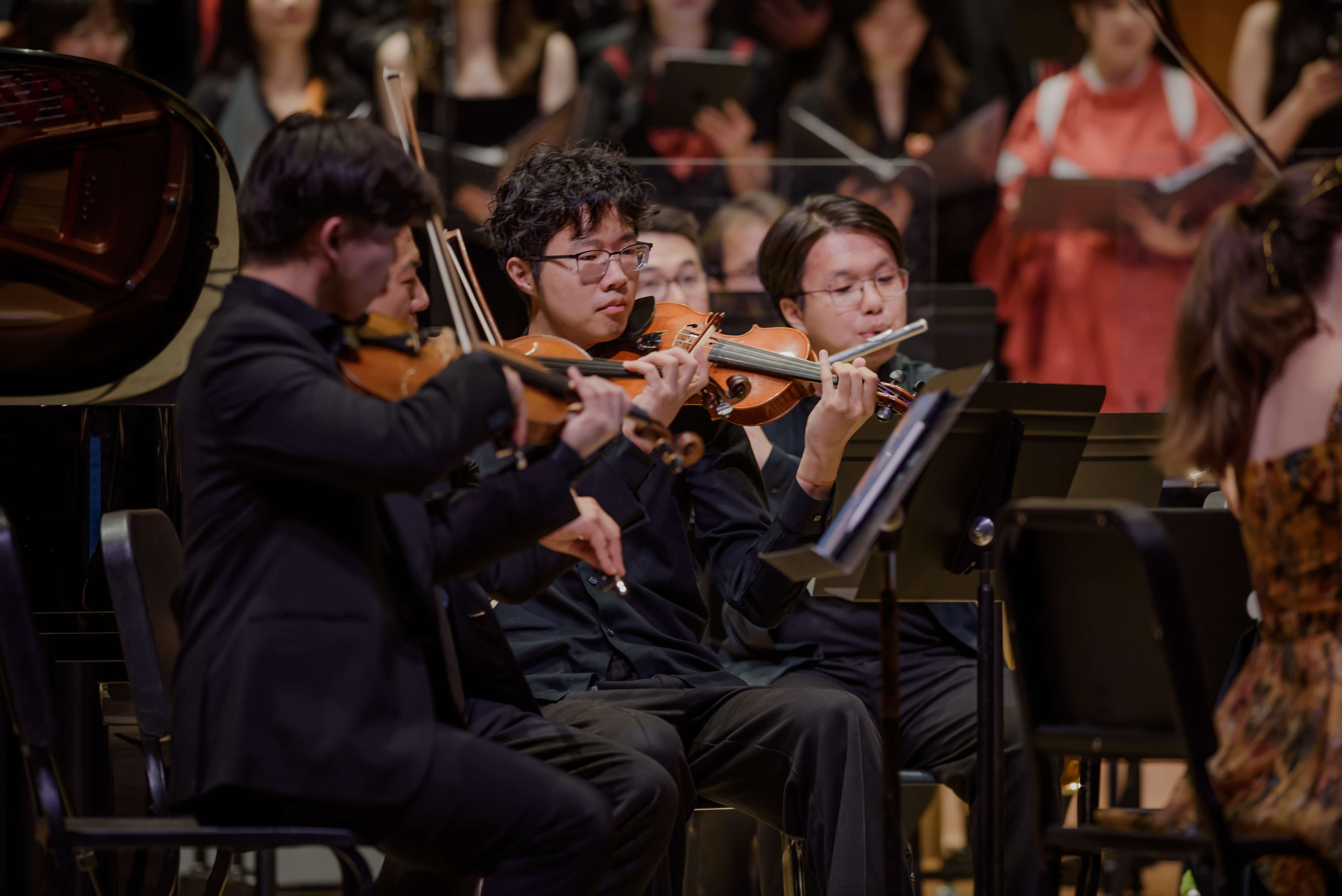 Violinists performing on stage during a GG Orchestra concert
