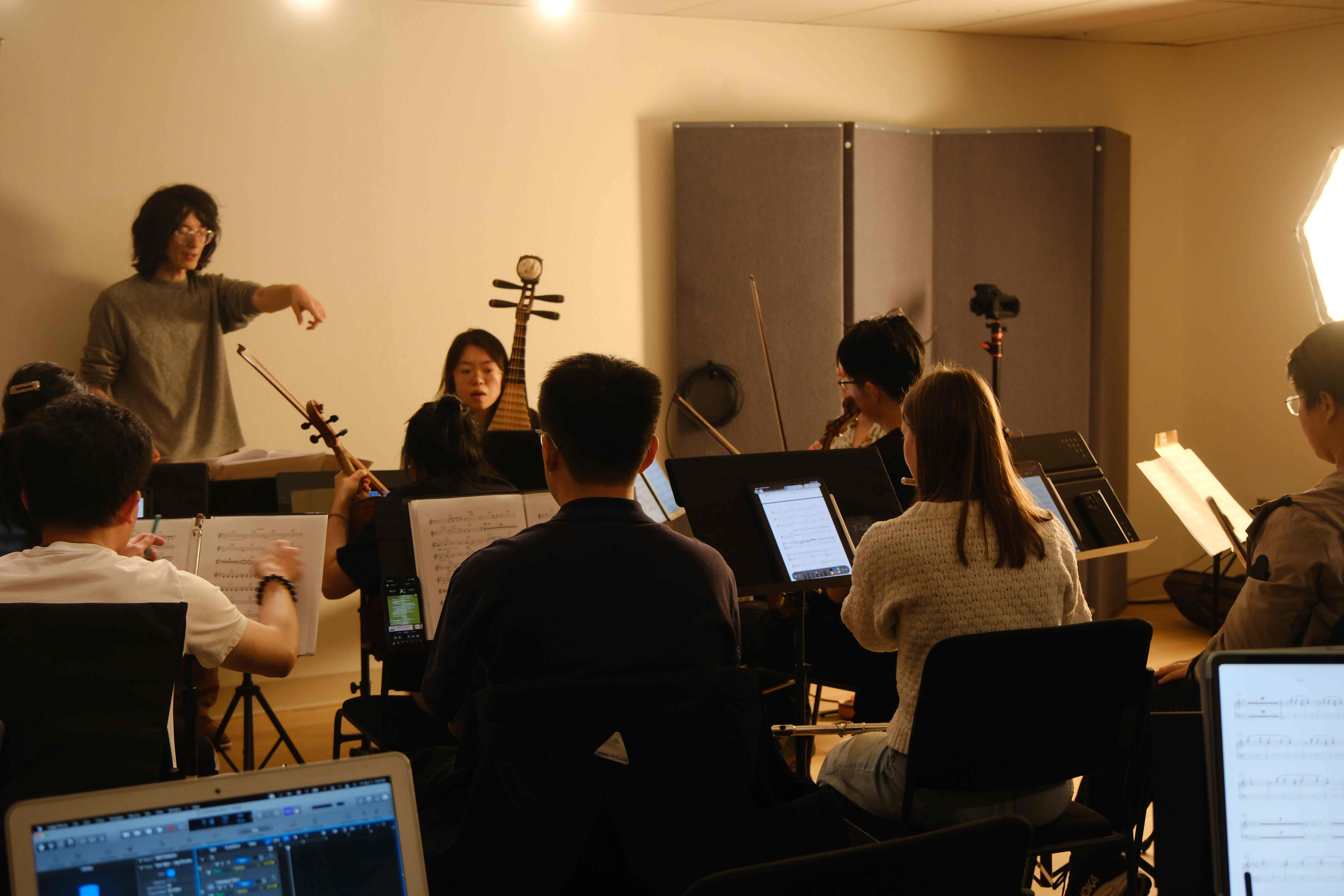 Studio recording session with conductor directing chamber ensemble including pipa player