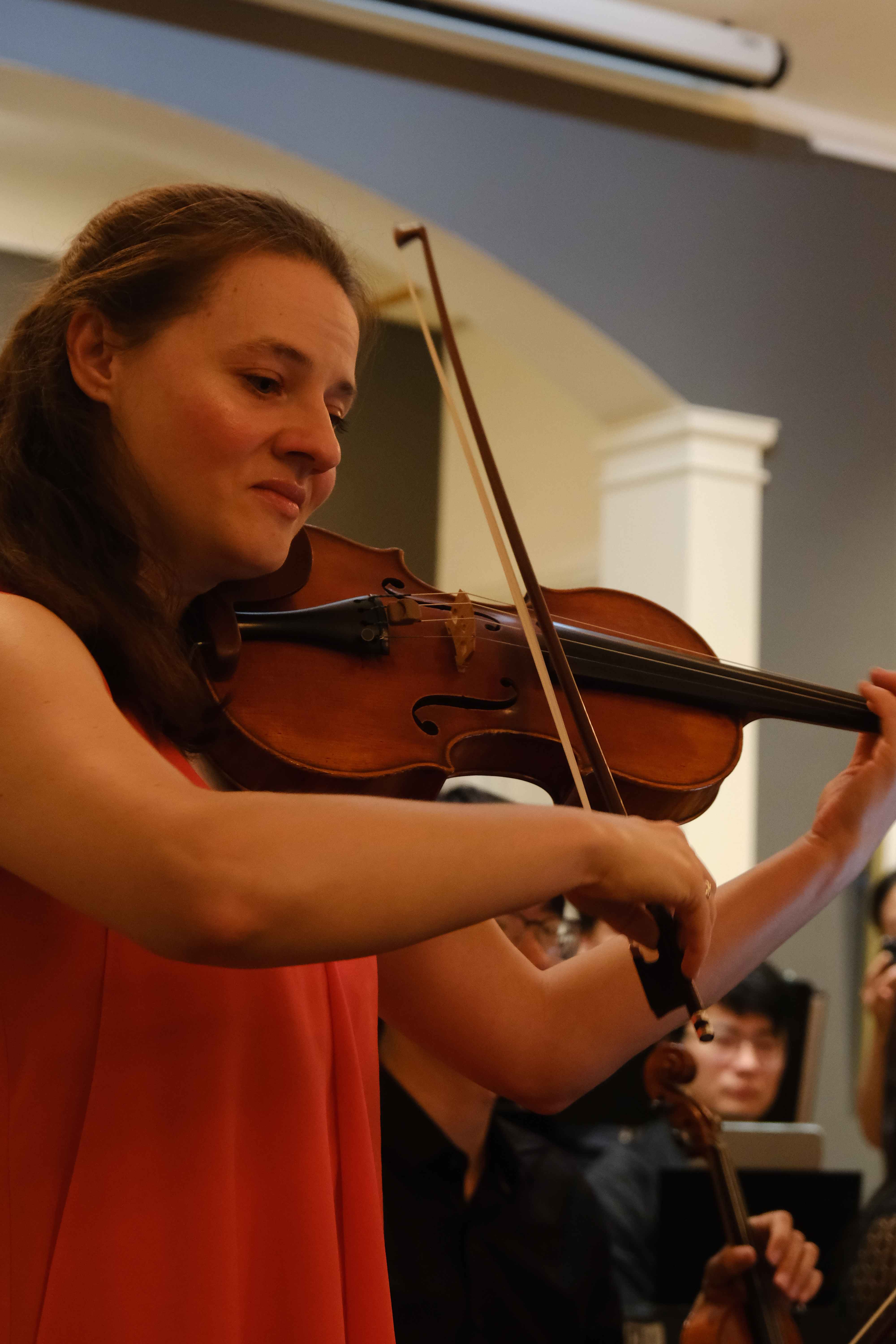 Violinist in coral dress performing solo