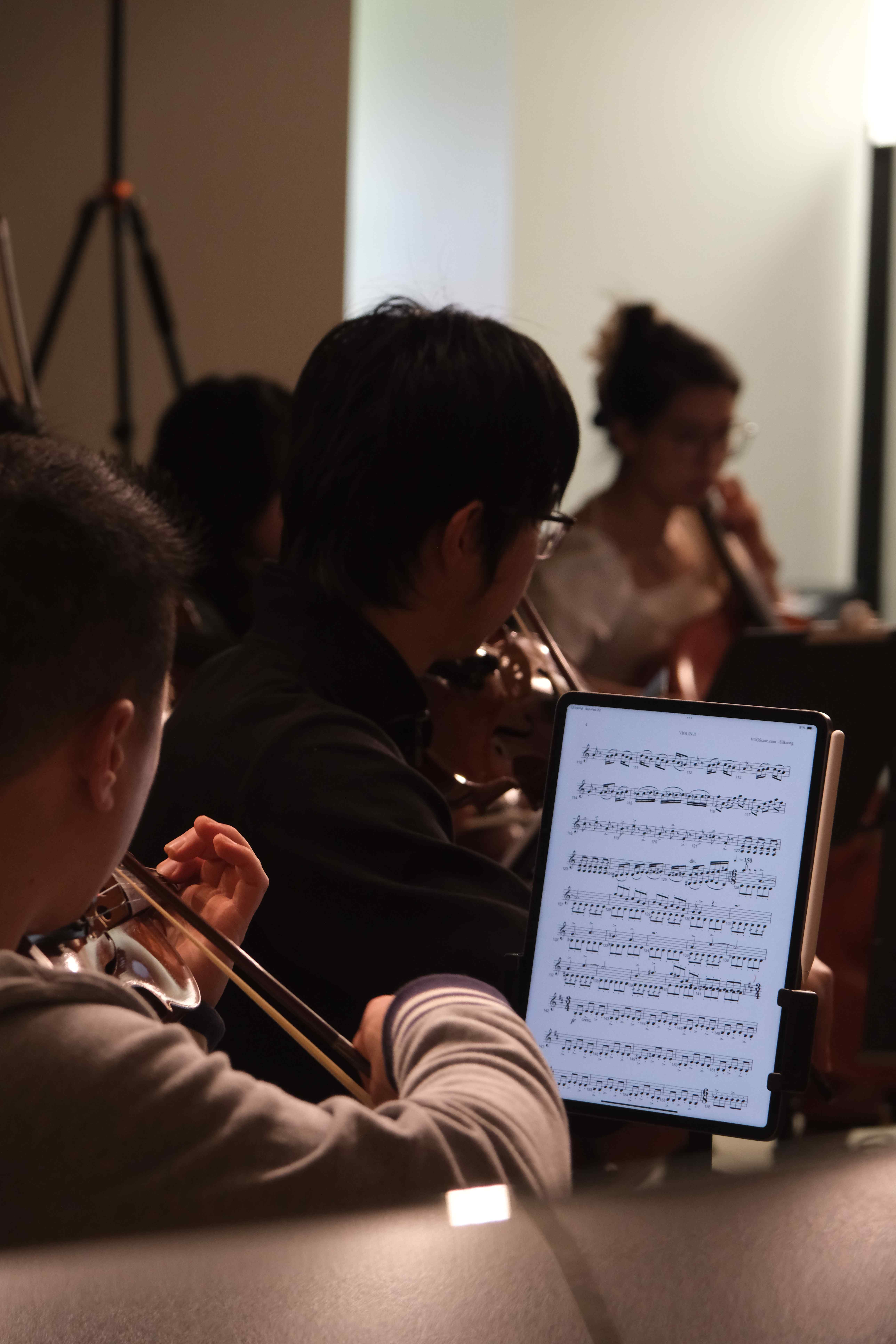 Musician viewing sheet music on tablet during rehearsal