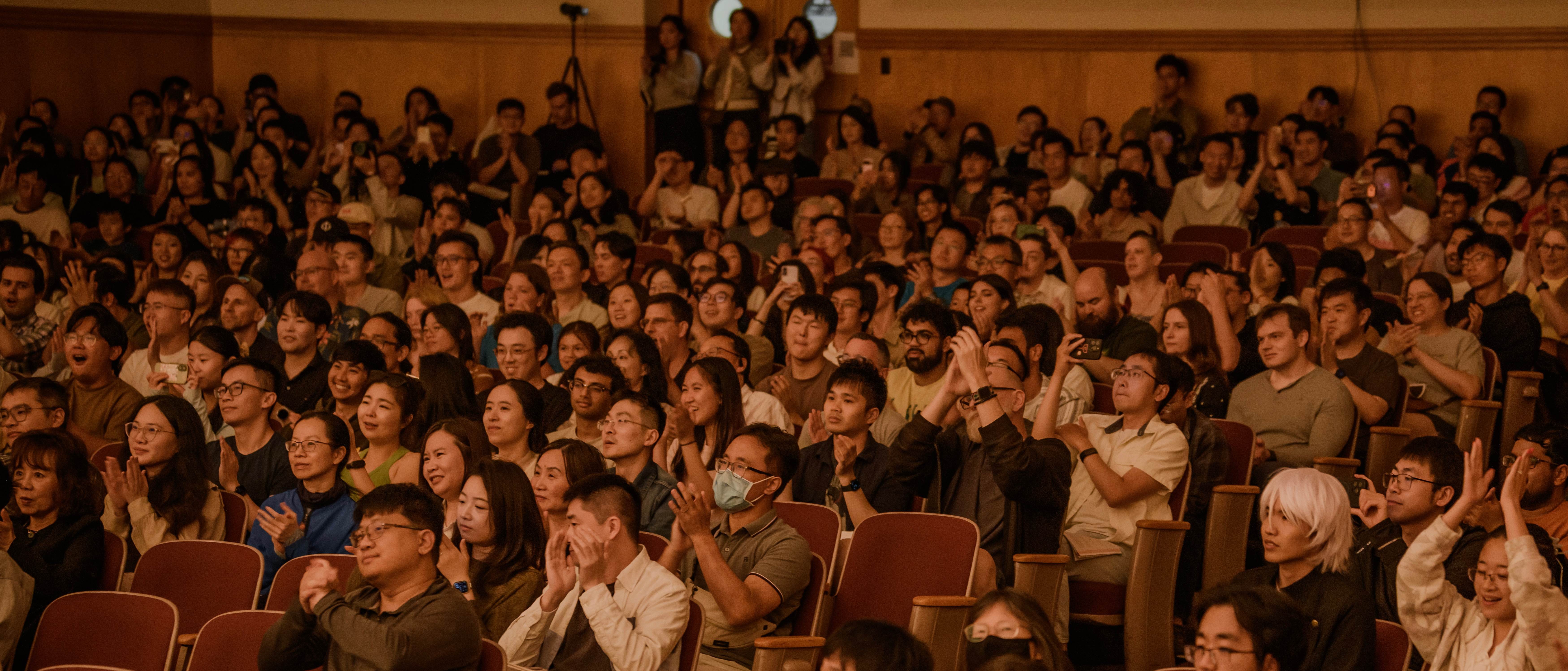 A full house of concertgoers applauding at a GG Orchestra performance