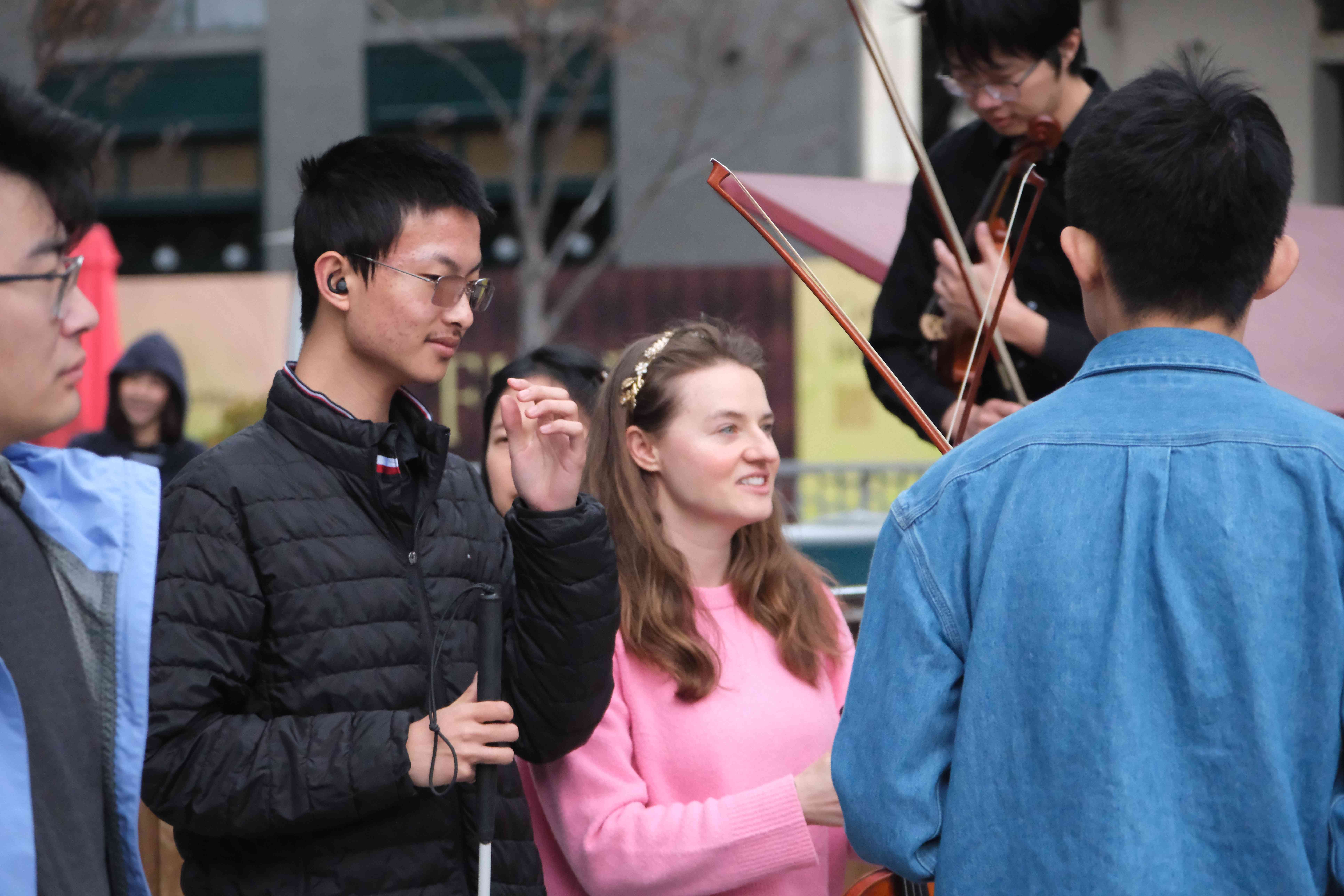 A blind attendee and other community members gathered together at a GG Orchestra pop-up performance